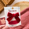 Detailed view of a handmade red velvet bow hair clip on a grid card held in hand - Red Velvet Basic Bow Set 2Pcs