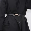 Schmaler schwarzer Ledergürtel mit goldener Koppelschnalle auf einem schwarzen Blazer - Schwarz