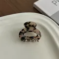 Detailopname van kleine haarklem van acetaat met schildpadmotief op keramische schaal - Lichte Luipaardprint