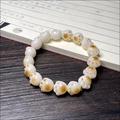 Detailed view of charred cat paw bodhi root beads on dark wood with calligraphy - Carbonized Cat Paw