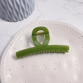 Detail of a grass green resin hair claw clip with golden metal spring on a tray - Turquoise Green - Butterfly Buckle Straight (Approx 11.3cm)