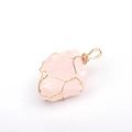 Detail of handmade gold wire-wrapped rose quartz crystal pendant on white background - Light Rose Quartz