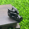 Close-up of a 1.5-inch black natural stone dragon head sculpture on a dark wooden surface - Obsidian