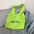 Neon green canvas tote bag with ARE YOU lettering on a soft fabric sofa - Fruit Green