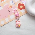 Close-up of pink rabbit keychain holding a carrot on a cute plaid background - Pink Satchel Rabbit