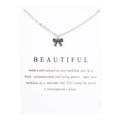 Macro shot of a silver bow pendant necklace on a white display card with inspirational text - Bowknot White Card (YH6162) / Silver
