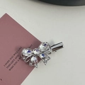 Detail shot of silver alloy bow hair clip with clear rhinestones on elegant backdrop - Silver/White Zirconia-Bowknot