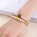 Détail de bracelets perlés ethniques empilés avec accents dorés et pierres turquoise - Jamais Séparés