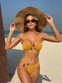 Detail of yellow ribbed bikini featuring decorative beads and halter neck on the beach - Yellow