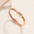 Elegante roségoudkleurige roestvrijstalen armband met zirkoon hoefijzergesp en schroefdetails - Riemgesp Stijl / Roségoud