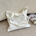 Close-up of white canvas tote bag with metal zipper on a cozy minimalist sofa - Two White Zippers