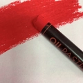 Single red professional oil pastel showing vibrant color and heavy impasto texture - Red