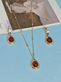 Golden drop necklace and hoop earrings set featuring elegant red oval gemstones - Gemstone Style / Red