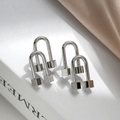 Irregular silver U-shaped geometric stud earrings with cube ends on a book background - Silver
