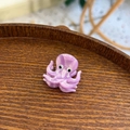 Detailed macro view of a purple marbled acetate octopus hair claw clip on wooden tray - Mini Purple Octopus