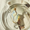 Handcrafted opal raw stone pendant with 18K gold wire wrapping in a glass dish - Gold Wire Opal