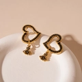 Detail of vintage gold heart earrings with black zircon stones and iconic orb pendant - Silver Pin - Black Heart Saturn Dangle Earrings