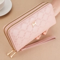 Pink double zipper long wallet with wristlet held near a coffee cup on warm background - Pink