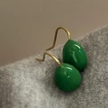Detalle de pendientes de gota verdes con ganchos dorados sobre fondo de tela gris - Gancho de Oreja Dorado Verde