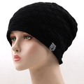 Detail of black knit beanie with fleece lining, featuring a square woven label and textured grid - One Size / Black
