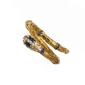 Macro shot of gold snake ring with micro-paved blue and white zircon gemstones - Gold Blue Eye Snake