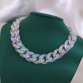 Auffällige bunte Acryl-Gliederkette mit schillerndem Finish auf einer grünen Büste - Transparenter Holografischer Stil / AB Weiß