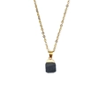 Detalle de un colgante de piedra negra natural con borde dorado en una fina cadena de oro - Aprox. 11*18mm / Piedra Negra