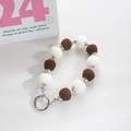 Detail view of brown and white plush pom-pom charms with silver beads and metal spring ring - Cream & Coffee