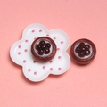Primer plano de botones marrones vintage con diseño floral sobre un plato blanco decorativo - Tarta de Huevo con Chocolate