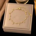 Detailed macro view of golden titanium steel bead bracelet on a premium jewelry display - Round Bead Chain Bracelet / Gold