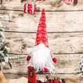 Gnome de Noël avec chapeau en tricot rouge et barbe en peluche sur un fond de bois brun - Style C Gnome de la Forêt (Chapeau Rouge à Flocons)