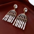 Detalle de pendientes vintage dorados con flecos de cristal sobre seda - Estilo de Borla con Pin de Plata / Dorado