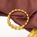 Dettaglio ravvicinato della struttura a molla dorata e degli inserti metallici cilindrici - Oro