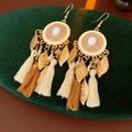 Detail of vintage enamel tassel earrings with cream beads on dark green velvet padding - Earrings-White