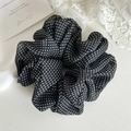 Detail showing high-elasticity black polka dot mesh hair scrunchie on white lace background - Black Polka Dot