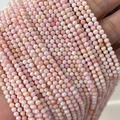 Faceted small pink natural stone beads for DIY jewelry making held in hand - Queen Conch Shell 3mm