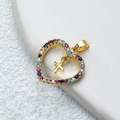 Pendentif cœur doré serti de pierres multicolores avec petite croix sur fond blanc - Cœur de Croix-Or/Multicolore