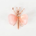 Makro-Detail des Roségold-Schmetterlings mit glatten, herzförmigen rosa Kristallflügeln - Rosenquarz