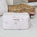 Dettaglio della borsa da trucco trapuntata bianca con fiocchi rosa e pois grigi - Wristlet