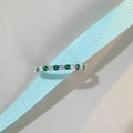 Macro view of emerald and white round-cut gemstones in an S925 sterling silver band - Green Zirconia