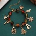 Detail of Christmas beaded bracelet with Santa Claus and reindeer charms on dark green background - Glass Bead Circular Style (2226)