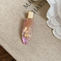 Dettaglio macro della clip per capelli iridescente con strass colorati su base dorata - Stile Strass Rosa