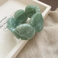 Detailopname van een groen gemarmerde acryl armband op een wit keramisch dienblad - Smaragdgroen