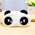 Dettaglio della maschera da notte a forma di panda in morbido peluche su legno - Occhi Supplichevoli
