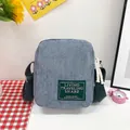 Light blue corduroy crossbody bag with green square label on checkered fabric - Haze Blue