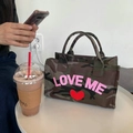 Borsa tote in tela mimetica con stampa Love Me e dettaglio a cuore su tavolo bianco - Mano e Tracolla Doppio Uso / Camouflage