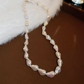 Close-up of white baroque pearl necklace with silver clasp on deep brown tray - White (Small)