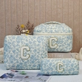 Three-piece set of blue floral quilted cotton makeup bags with plush letter C patch - White Background With Orchid And Letter C