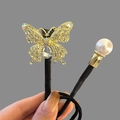 Élastique papillon élégant avec zircons brillants, un grand cristal et un détail de perle - Chignon Papillon Or