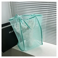 Detail of light green mesh tote bag with reinforced handles in a modern home setting - Blue